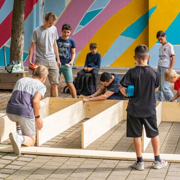 Schülerinnen bauen ein Sitzpodest für eine Schulhofgestaltung gegen Vandalismus mit Handwerksförderung in Konstanz