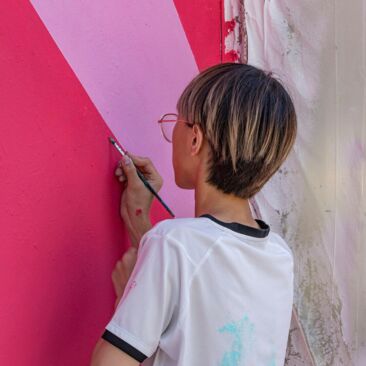 Schülerinnen streichen eine Wand für eine Schulhofgestaltung gegen Vandalismus mit Handwerksförderung in Konstanz