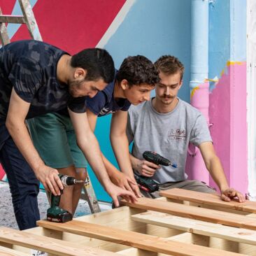 Schülerinnen bauen ein Sitzpodest für eine Schulhofgestaltung gegen Vandalismus mit Handwerksförderung in Konstanz