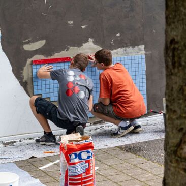 Schülerinnen erstellen ein Fliesenbild für eine Schulhofgestaltung gegen Vandalismus mit Handwerksförderung in Konstanz