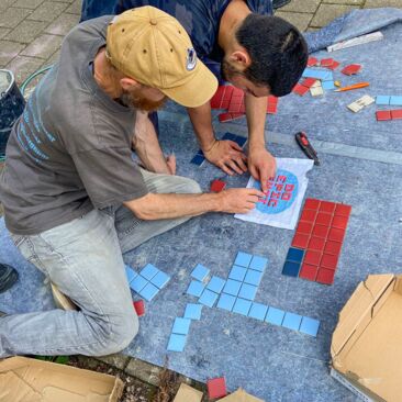 Schülerinnen planen ein Fliesenbild für eine Schulhofgestaltung gegen Vandalismus mit Handwerksförderung in Konstanz